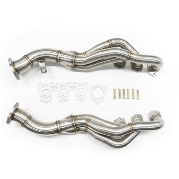 A pair of stainless steel exhaust headers with matching gaskets, washers, and mounting hardware, displayed on a clean white background.