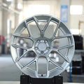 Silver multi-spoke alloy wheel for Audi performance cars in a workshop setting.