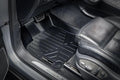 Black custom-fit floor liner in the front footwell of an Audi with leather seats