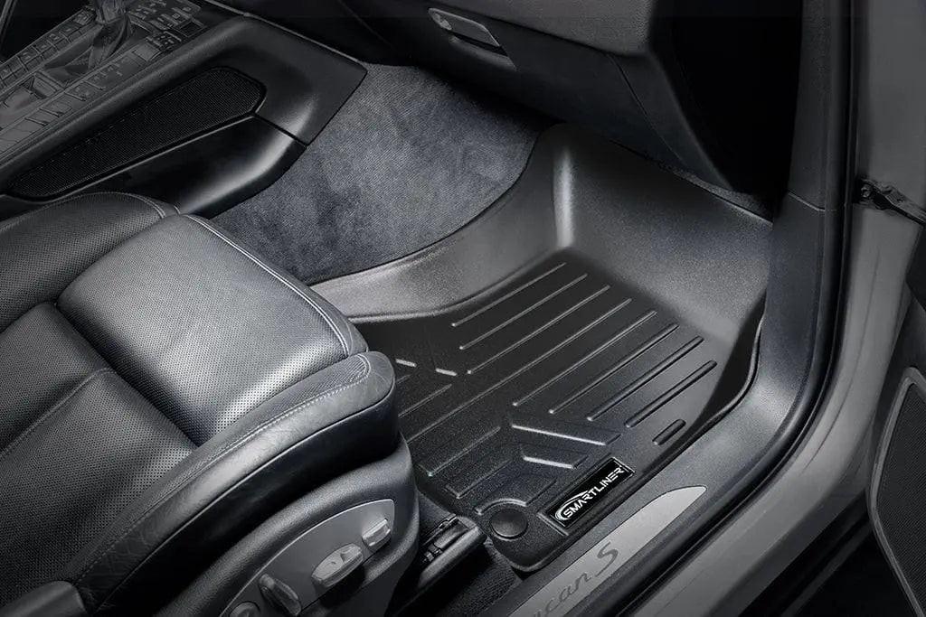 Custom black car floor mat in passenger footwell, close-up in luxury vehicle interior