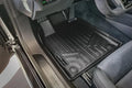 Custom fit black rubber floor mat in Audi car interior, close-up driver side