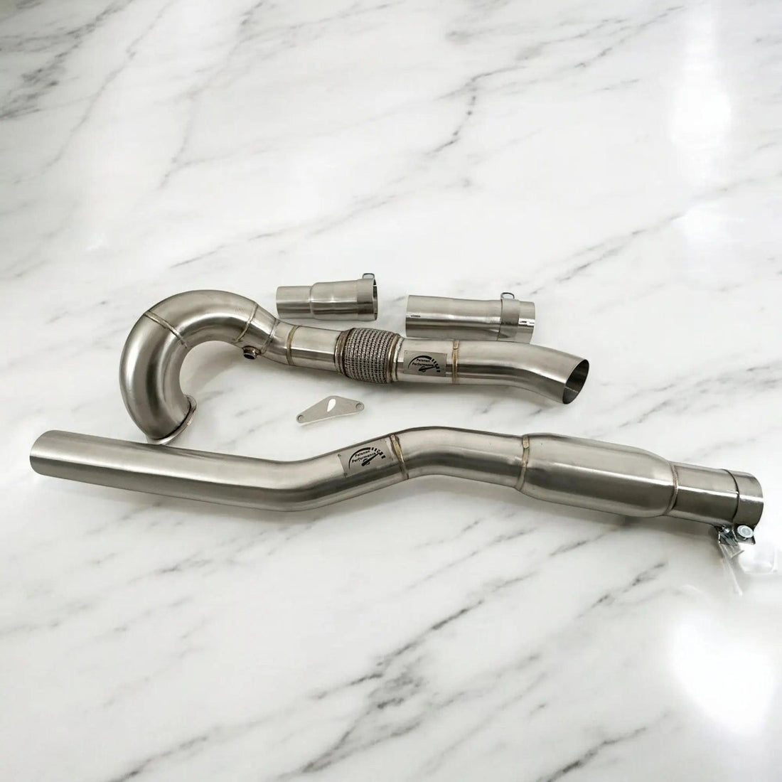 Stainless steel downpipe kit for Audi A3 S3 AWD displayed on white marble surface