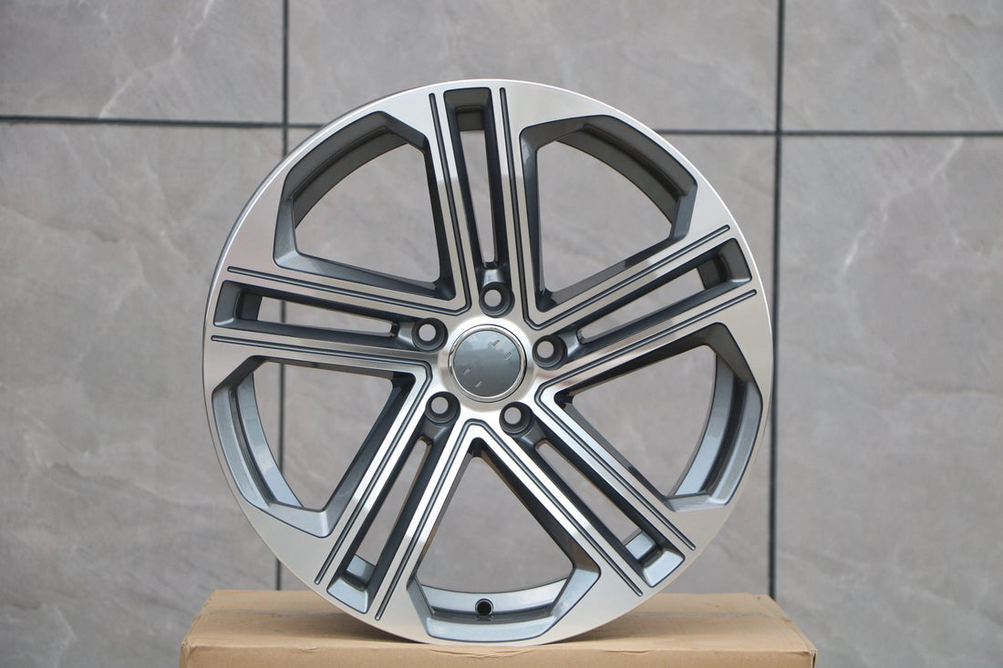 Audi S4 replica wheel, split-spoke alloy design, grey and machined face, against tile backdrop