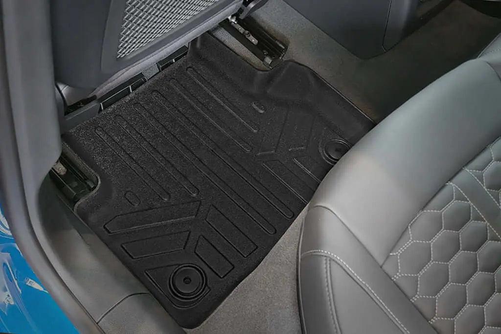 Custom-fit black Audi rear floor mat in car interior with quilted leather seat