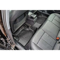 Rear car seat interior with black custom fit all-weather floor mats and leather seats