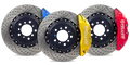 Three performance drilled brake rotors with blue, yellow, and red calipers for Audi
