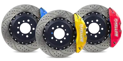 Set of three slotted and drilled performance brake rotors with red, yellow, and blue calipers