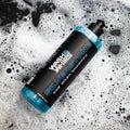 Silverstone Wash & Whips car wash shampoo bottle on soapy surface with black stones