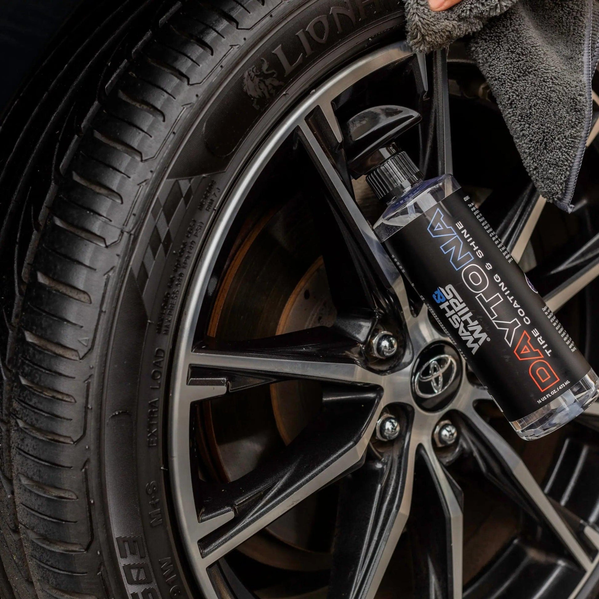 Close-up of car tire and alloy wheel being cleaned with DAYTONA tire shine spray
