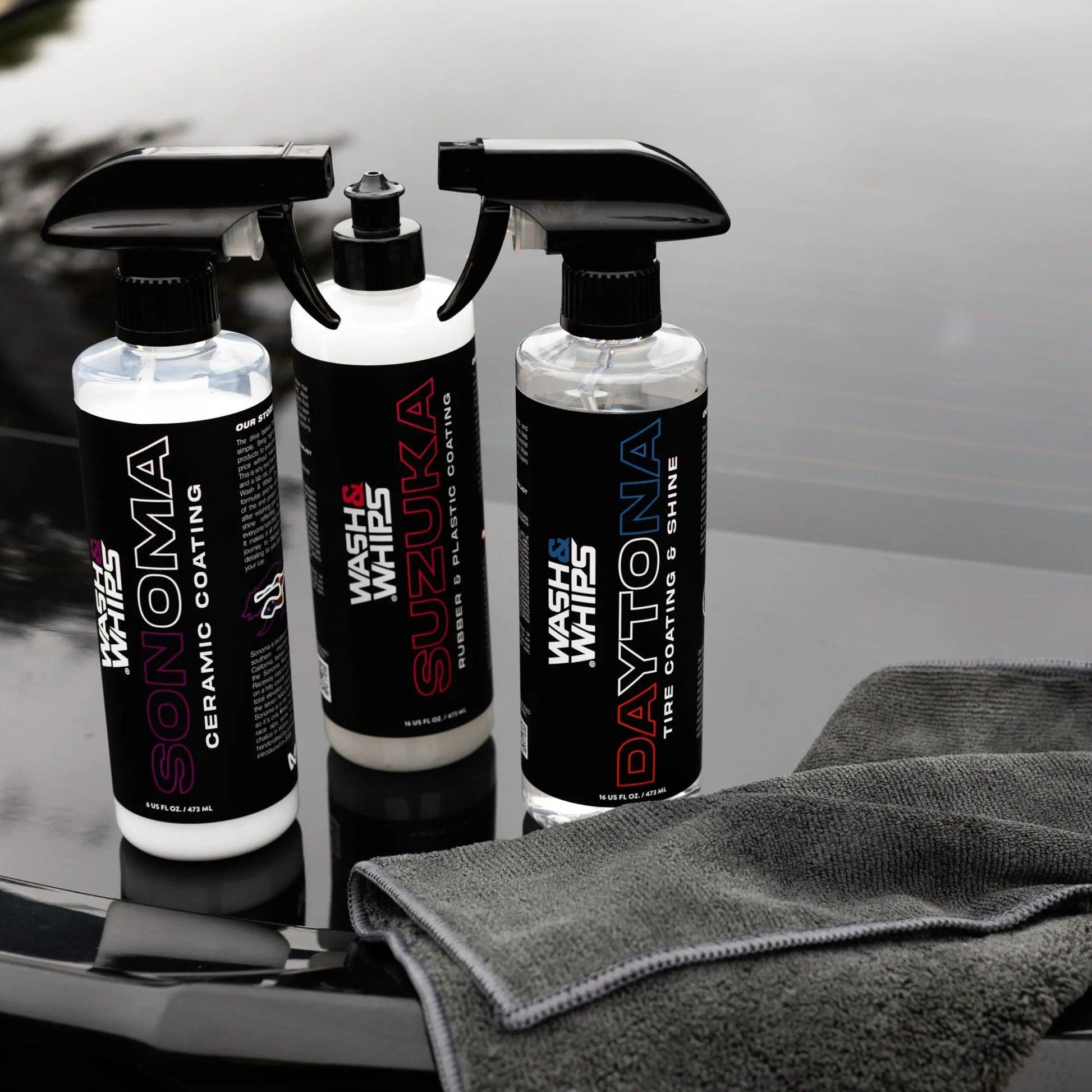 Car detailing products Sonoma ceramic coating, Suzuka rubber and plastic coating, Daytona tire shine bottles with microfiber cloth on car hood