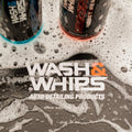 Car wash and detailing products with soap suds, featuring Wash & Whips branding