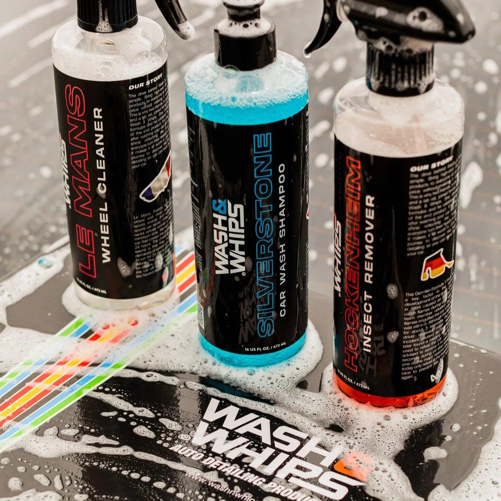 Car cleaning products bottles with labels for wheel cleaner, car wash shampoo, and insect remover, surrounded by soap suds