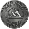 Metal badge with 'Vorsprung Forged' text, mountain outline, and geometric logo design.
