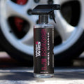 Wash & Whips Le Mans wheel cleaner spray bottle in front of a car wheel