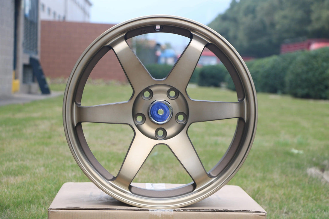 Bronze 5-spoke alloy wheel for Audi performance, outdoor product display on cardboard box