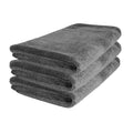 Stack of three gray microfiber premium car detailing towels on white background