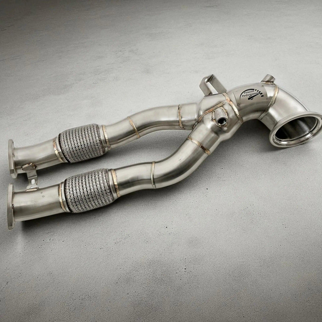 Stainless steel race downpipe for Audi 8V 8Y RS3 and 8S TTRS, shown on a grey surface.