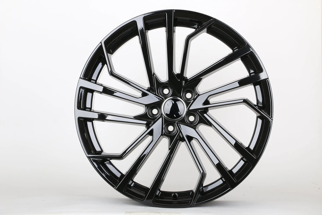 Gloss black multi-spoke alloy wheel for performance Audi vehicle on white background