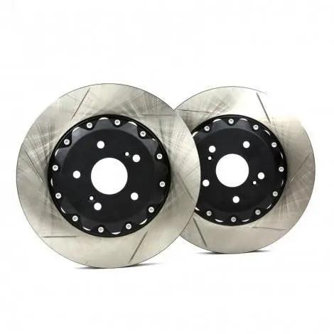 Pair of performance Audi brake rotors with slotted design on white background