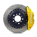 Drilled slotted brake rotor with yellow performance brake caliper for Audi vehicles