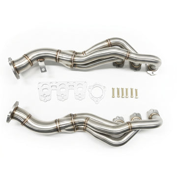 A pair of stainless steel exhaust headers with matching gaskets, washers, and mounting hardware, displayed on a clean white background.