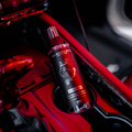 Blackline Car Care 8oz Wild Cherry car air freshener hanging in a vehicle, freshening the interior with a fruity scent.