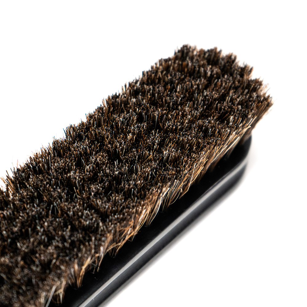 Blackline Leather Brush from Blackline Car Care with black bristles and ergonomic handle for cleaning leather surfaces.