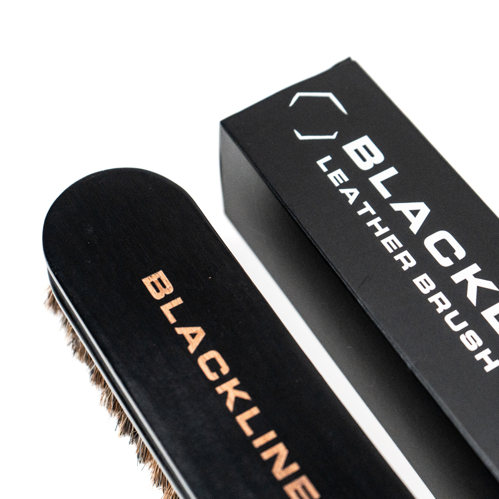 Blackline Leather Brush from Blackline Car Care, a black leather cleaning and conditioning brush with a sturdy handle.