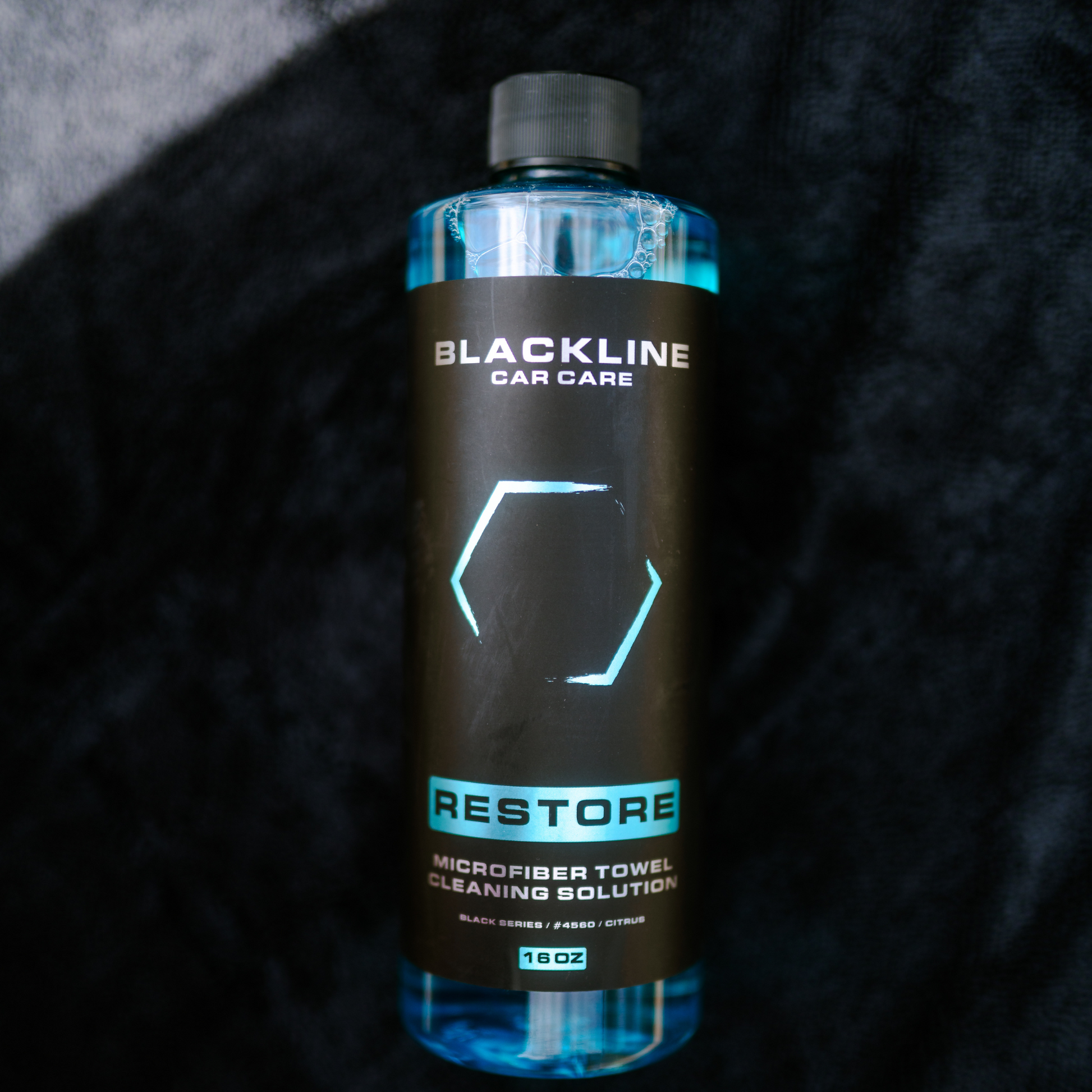 Blackline Car Care BLACKLINE® Restore microfiber detergent bottle, 16oz, with label and black cap, designed for cleaning microfiber fabrics.