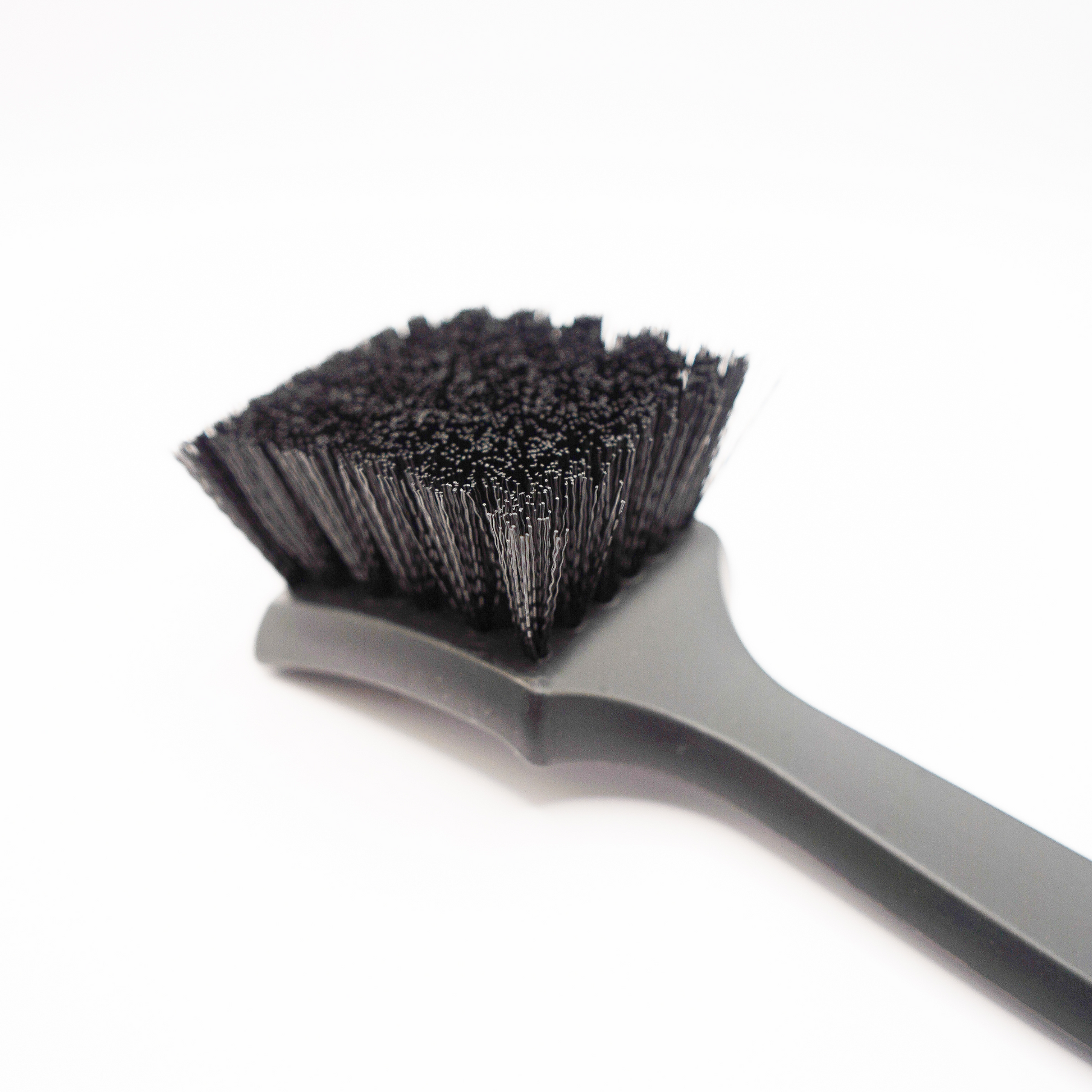 Blackline Car Care stiff bristle tire brush with durable handle for cleaning vehicle tires effectively.