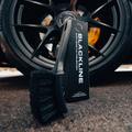 Blackline Car Care stiff bristle tire brush with black handle, designed for cleaning vehicle tires effectively.