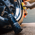 Blackline Car Care BLACKLINE® Blackout Trim and Tire Dressing spray applied to car trim and tires for a sleek, shiny finish.