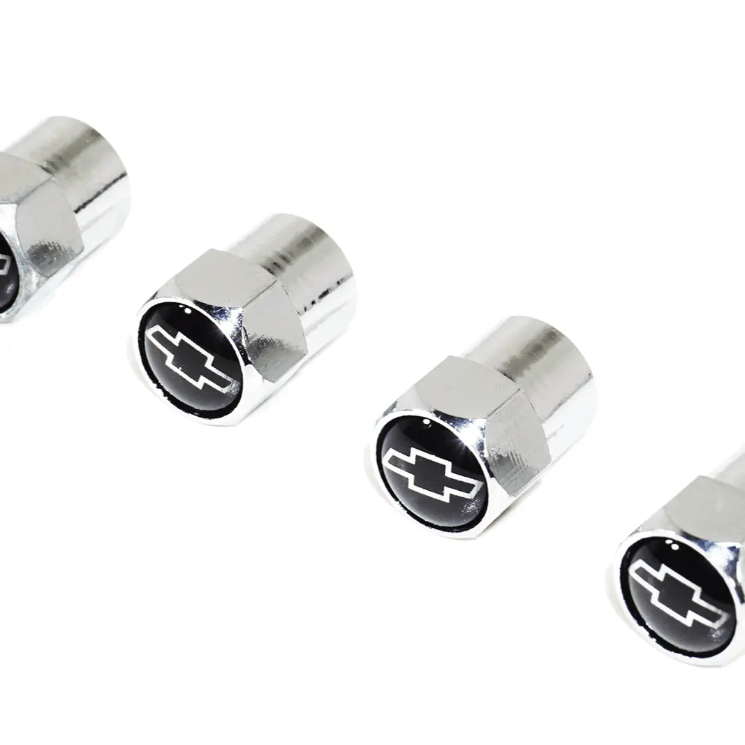 Black and chrome Chevy-style valve stem tire caps with ZSPEC Design logo, featuring a bow-tie design on a vehicle wheel.