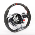 Close-up of the black Audi R8/TT steering wheel by Exclusive Steering with textured grip and branded logo at the center.