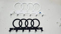 Steel wall-mounted Audi logo keychain rack by Martin Metalwork LLC, featuring an orange Audi emblem for car organization.