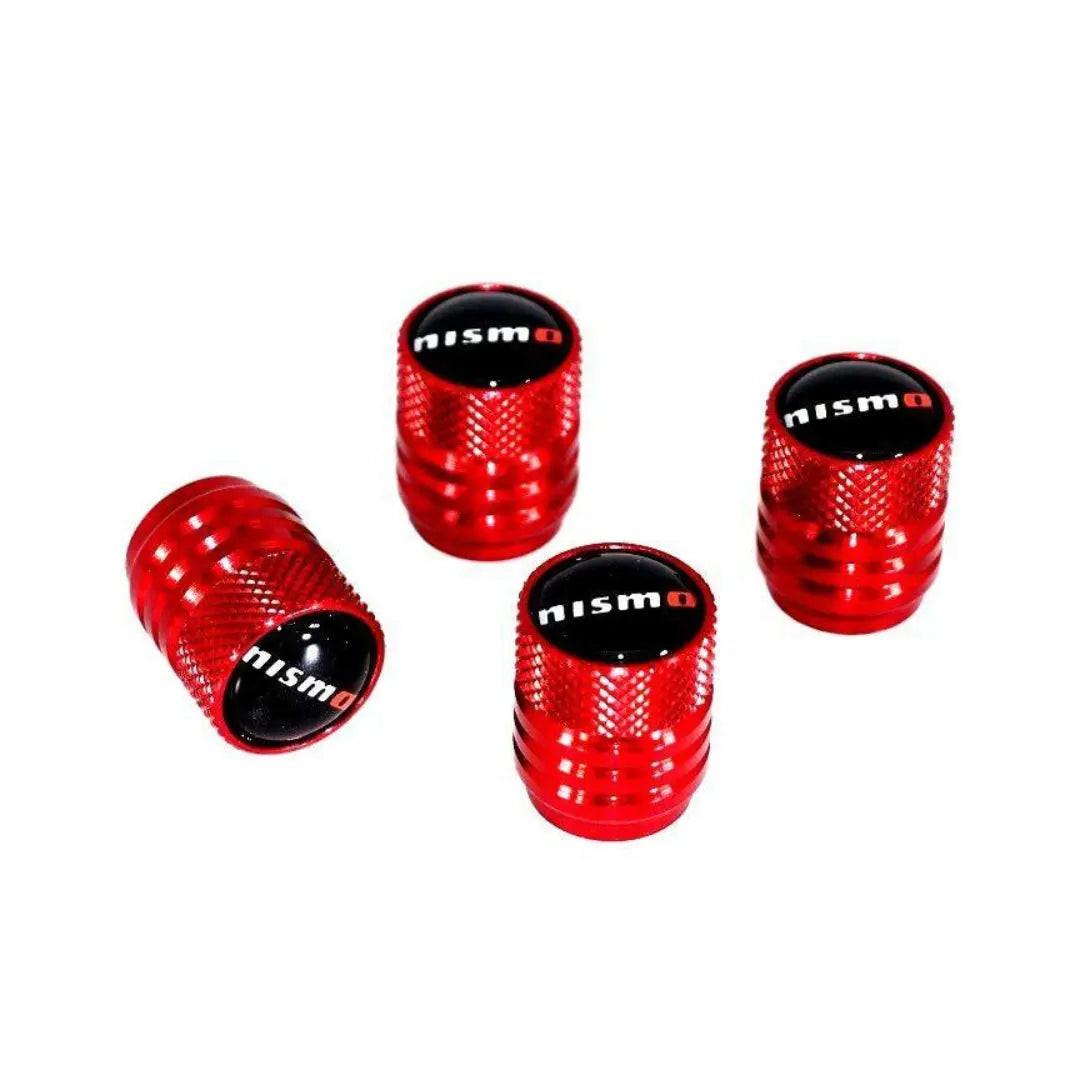 Red NISMO tire valve stem cap set for Nissan vehicles, featuring durable metal construction and sporty design.