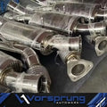 Stainless steel sport downpipes for Audi Q7 3.0T, wrapped for protection, on a workbench.