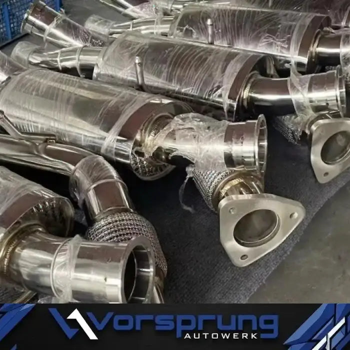 Stainless steel sport downpipes for Audi Q7 3.0T, wrapped for protection, on a workbench.