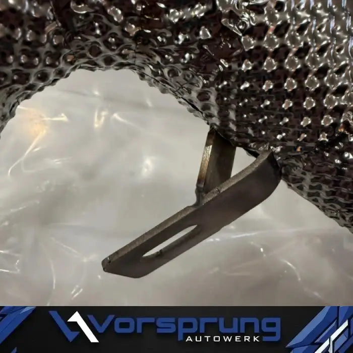 Closeup of textured heat-shielded Audi 3.0 supercharged test pipe with mounting bracket