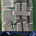 Stack of rectangular metal heat exchanger components with fins, Vorsprung Autowerk branding visible.