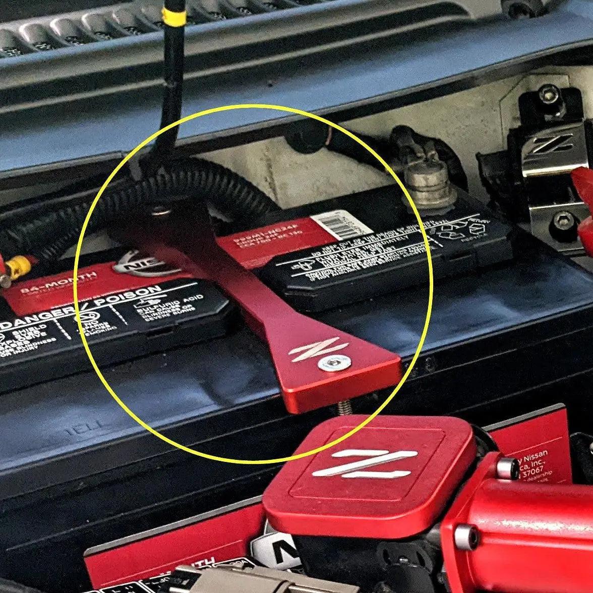 Red ZSPEC Design battery hold down bracket for Nissan Z32 300ZX, made of billet aluminum with stainless hardware.